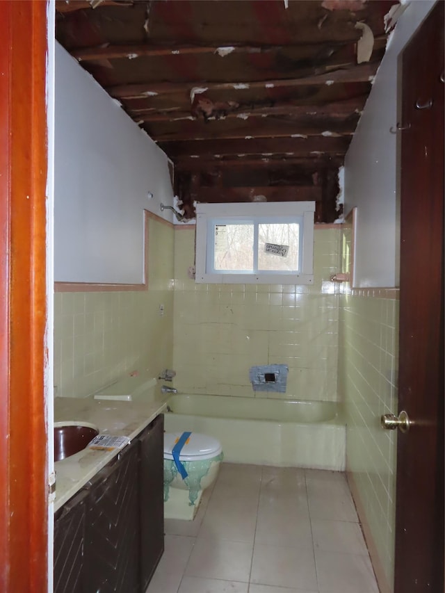 bathroom featuring vanity, tile walls, tile patterned flooring, toilet, and a bathing tub