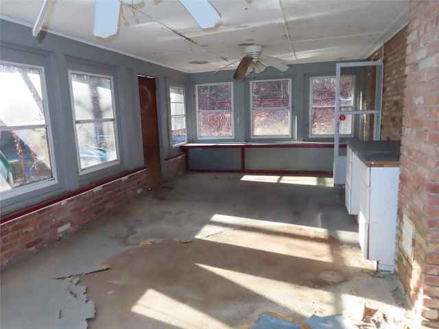 unfurnished sunroom with ceiling fan