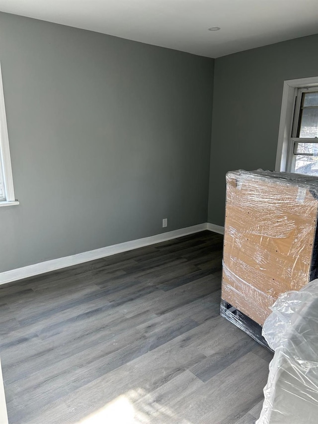 unfurnished room with dark hardwood / wood-style flooring