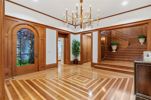 entryway featuring ornamental molding and a chandelier