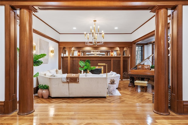 living room featuring light parquet flooring, crown molding, a chandelier, and decorative columns