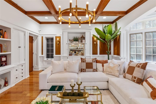 living room featuring light hardwood / wood-style flooring, an inviting chandelier, beam ceiling, and coffered ceiling