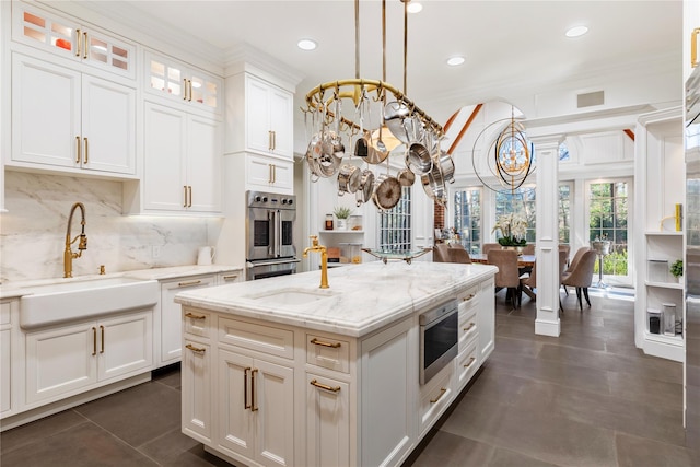 kitchen with appliances with stainless steel finishes, white cabinetry, and sink