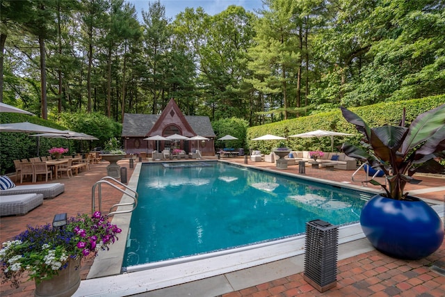 view of pool with an outbuilding and a patio