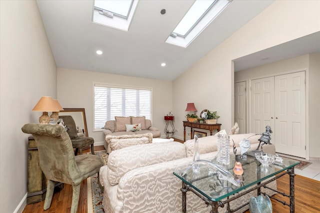 living room featuring vaulted ceiling with skylight