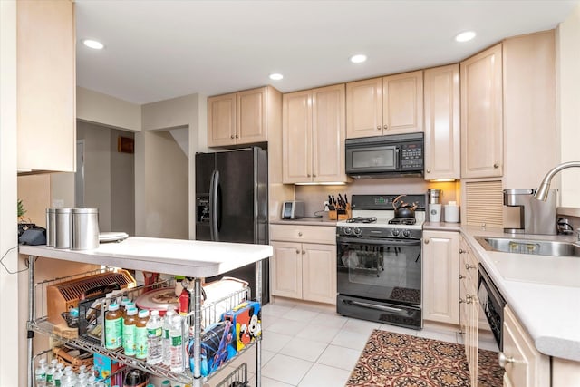 kitchen with light tile patterned flooring, black appliances, and sink