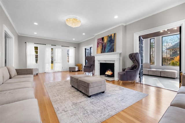 living room with recessed lighting, a fireplace, plenty of natural light, and light wood-style flooring