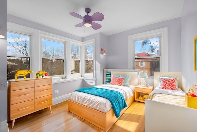 bedroom featuring baseboards, ceiling fan, and light wood finished floors