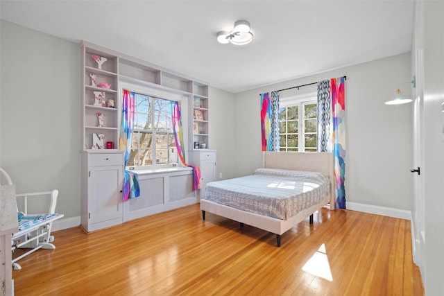 bedroom with wood finished floors and baseboards