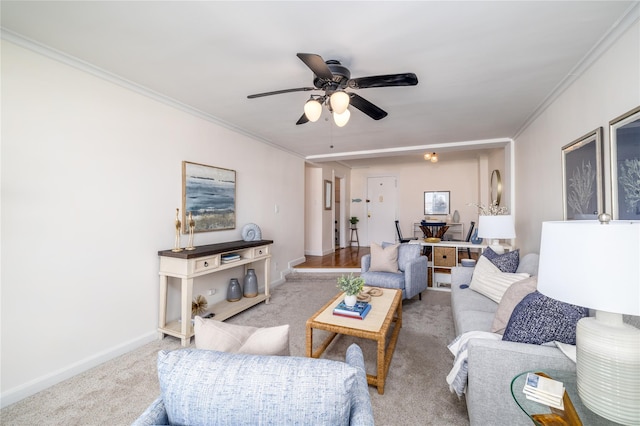 carpeted living room with ceiling fan and crown molding