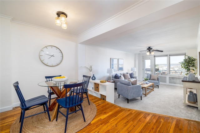 dining area with wood-type flooring, ceiling fan, and crown molding