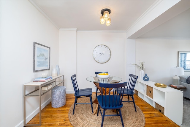 dining room with hardwood / wood-style flooring and ornamental molding