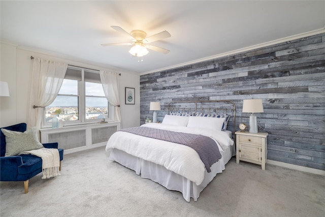 bedroom with ceiling fan, wooden walls, light colored carpet, and crown molding