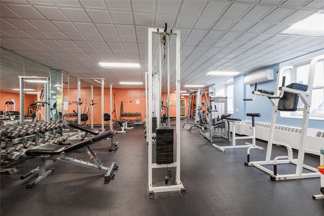 exercise room with a wall mounted air conditioner and radiator