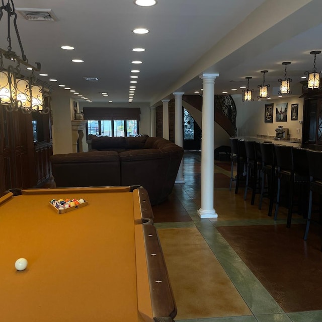 playroom featuring decorative columns and indoor bar