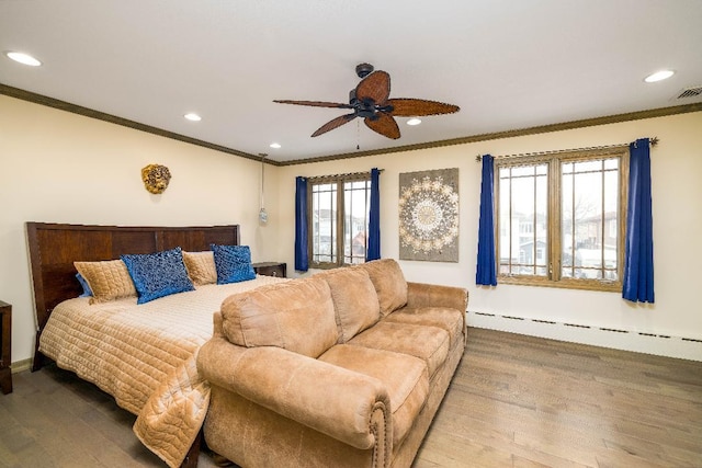 bedroom featuring ceiling fan, hardwood / wood-style flooring, multiple windows, and a baseboard heating unit