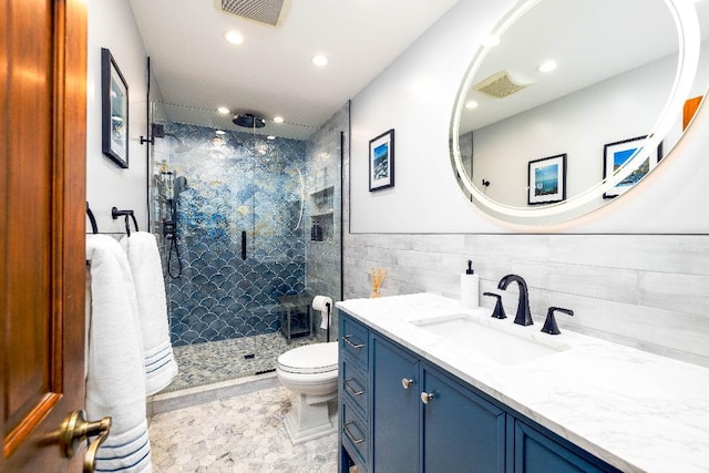 full bath featuring tile walls, visible vents, toilet, a shower stall, and vanity