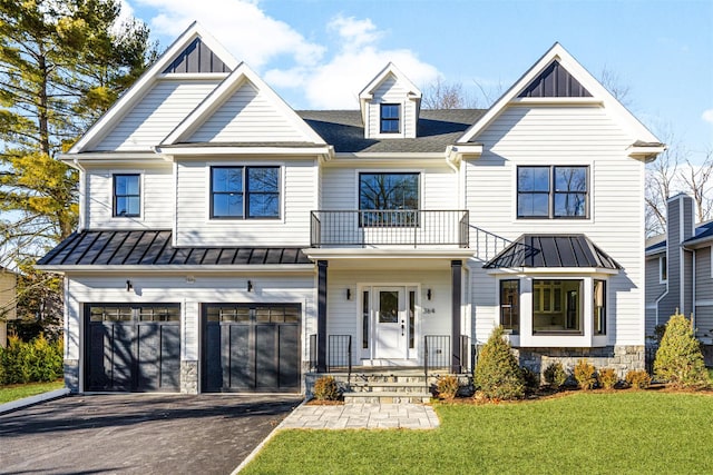 view of front of home featuring a balcony, a front lawn, and a garage