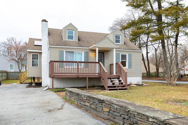 cape cod-style house with a deck and a front lawn