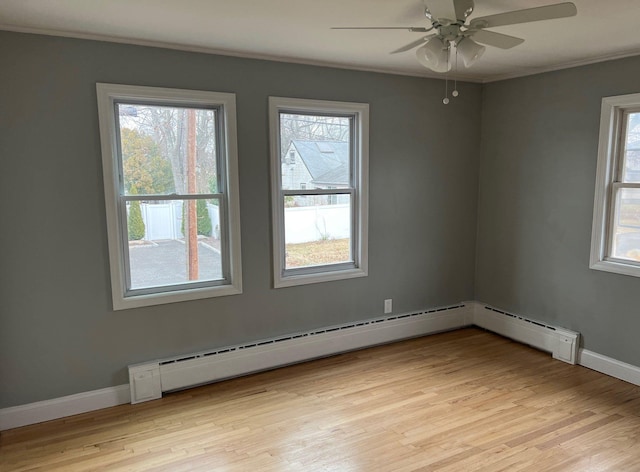 empty room with light wood-type flooring, baseboards, ornamental molding, and a wealth of natural light