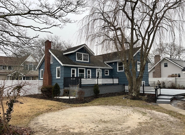 bungalow with a chimney, fence, and a wooden deck