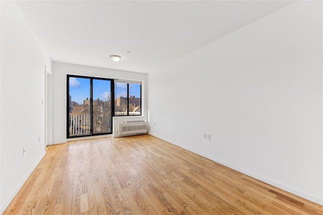 empty room featuring light hardwood / wood-style flooring and a wall mounted air conditioner