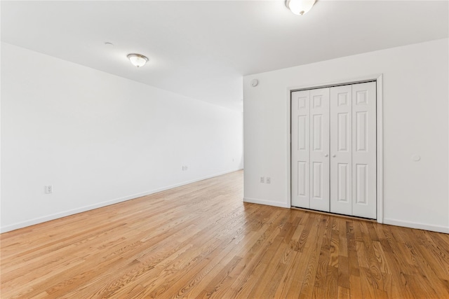 unfurnished bedroom featuring a closet and light hardwood / wood-style floors