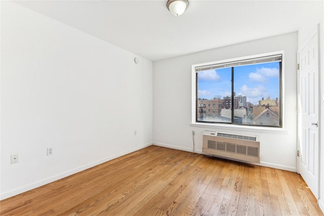 spare room featuring heating unit and light hardwood / wood-style floors