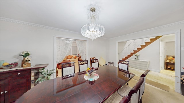 dining space with ornamental molding, a notable chandelier, and light hardwood / wood-style floors