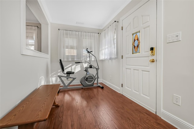 exercise area featuring dark hardwood / wood-style flooring and ornamental molding