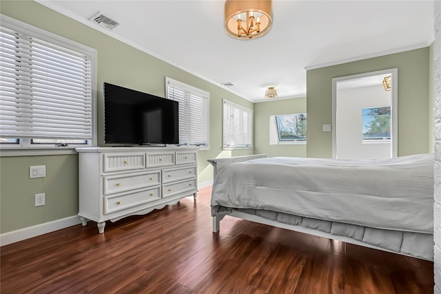 bedroom featuring an inviting chandelier, crown molding, and hardwood / wood-style floors