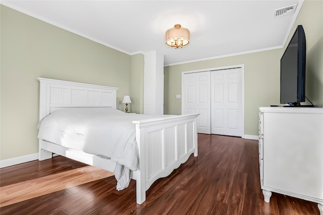 bedroom with a closet, dark hardwood / wood-style flooring, and ornamental molding