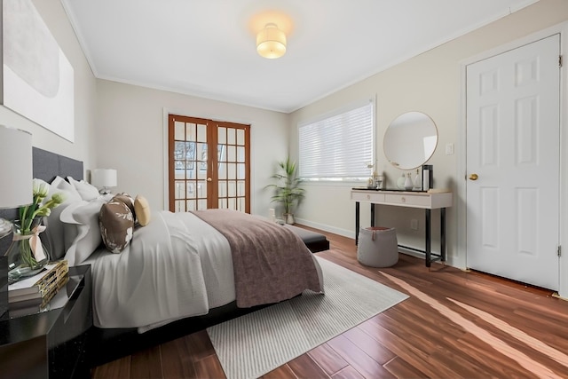 bedroom with french doors, dark wood-type flooring, and crown molding