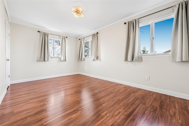 spare room featuring crown molding and wood-type flooring