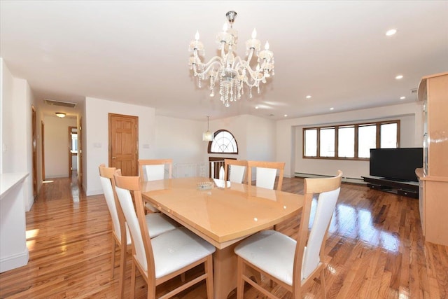 dining area featuring an inviting chandelier and light hardwood / wood-style flooring