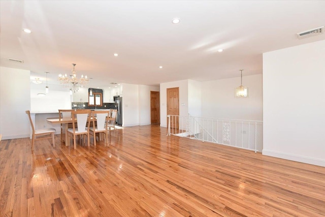 dining area featuring light hardwood / wood-style flooring and a notable chandelier