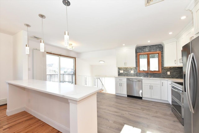 kitchen with stainless steel appliances, white cabinets, backsplash, and decorative light fixtures