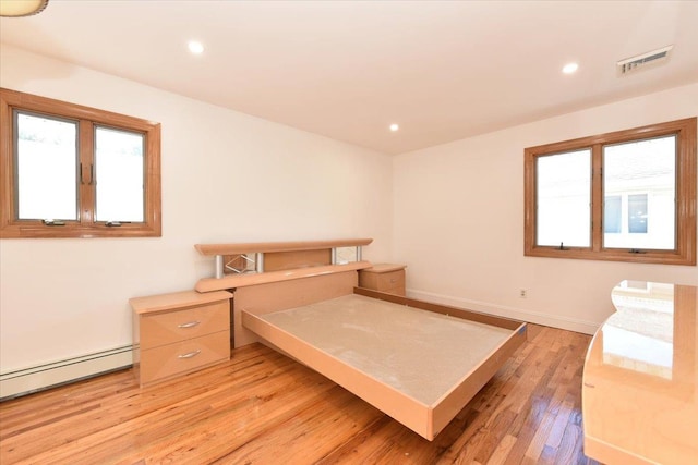 bedroom featuring a baseboard radiator and light hardwood / wood-style floors