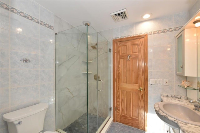 bathroom featuring vanity, tile walls, an enclosed shower, and toilet