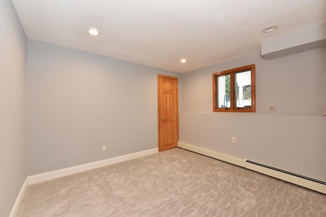 unfurnished room with a baseboard radiator and light carpet