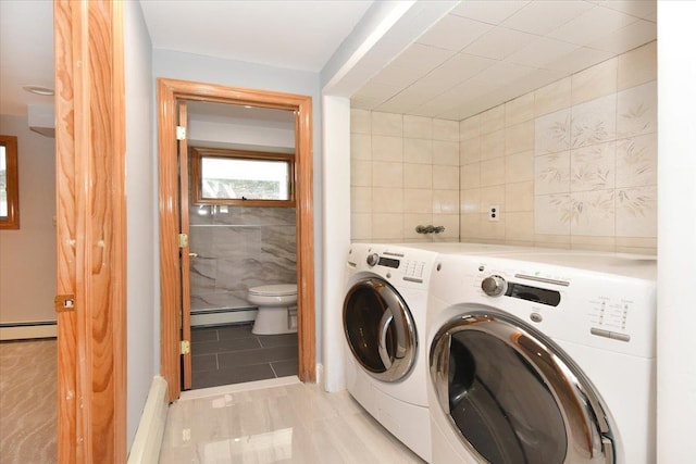 washroom featuring washer and dryer, tile walls, and baseboard heating