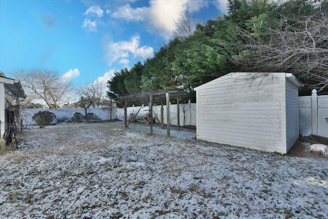 yard covered in snow with a storage shed