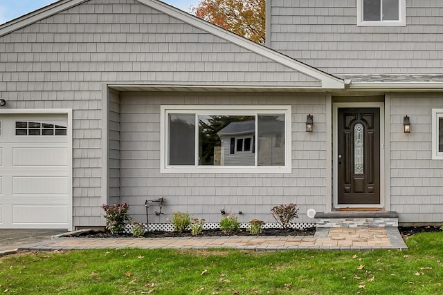 doorway to property featuring a garage and a yard