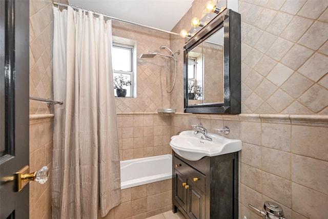 bathroom with tile walls, vanity, and shower / bath combo