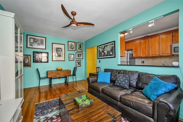 living room with ceiling fan, dark hardwood / wood-style floors, and rail lighting