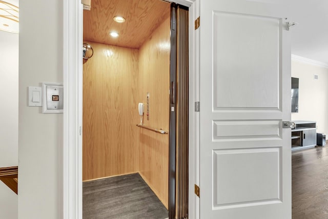 hall with elevator, crown molding, and dark hardwood / wood-style flooring