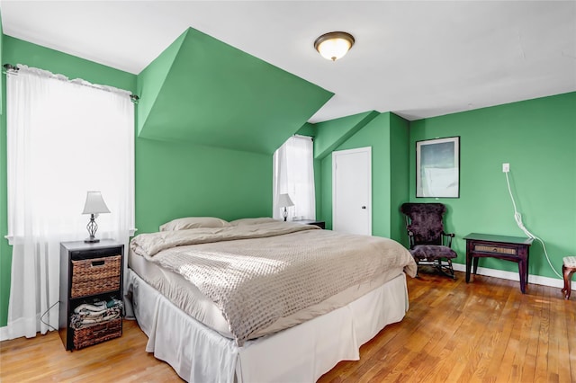 bedroom with multiple windows and hardwood / wood-style floors