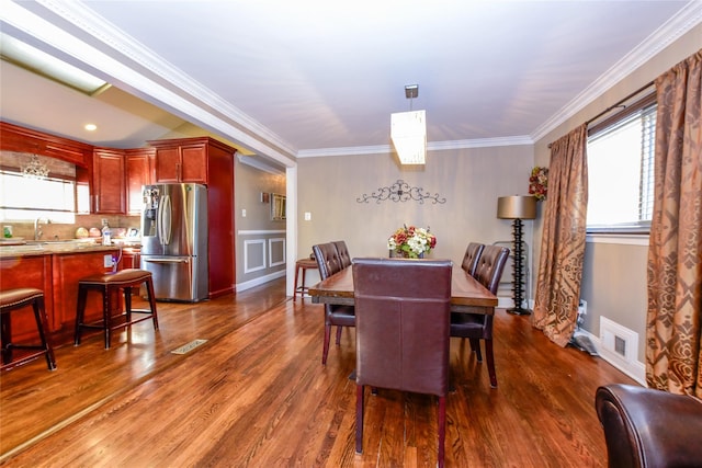 dining area featuring sink, dark hardwood / wood-style floors, and crown molding