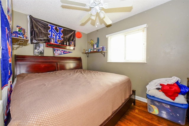 bedroom featuring ceiling fan, dark hardwood / wood-style flooring, and a textured ceiling