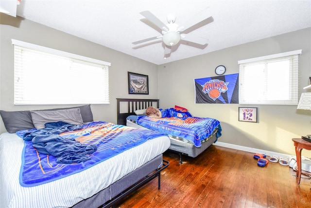 bedroom featuring dark wood-type flooring, ceiling fan, and a textured ceiling